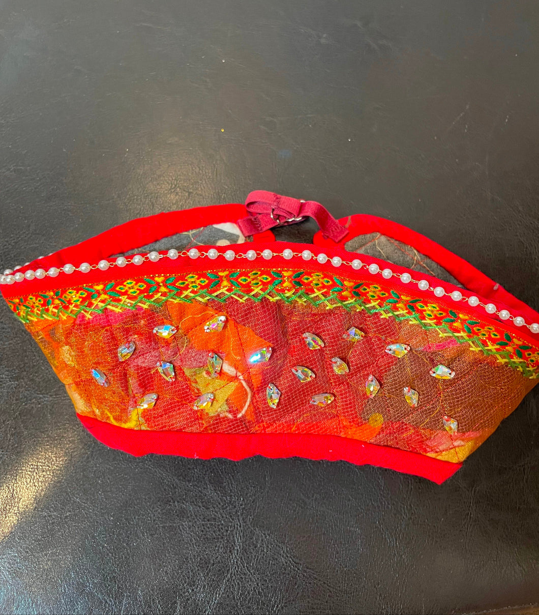 Decorative red headdress with floral patterns on a black surface