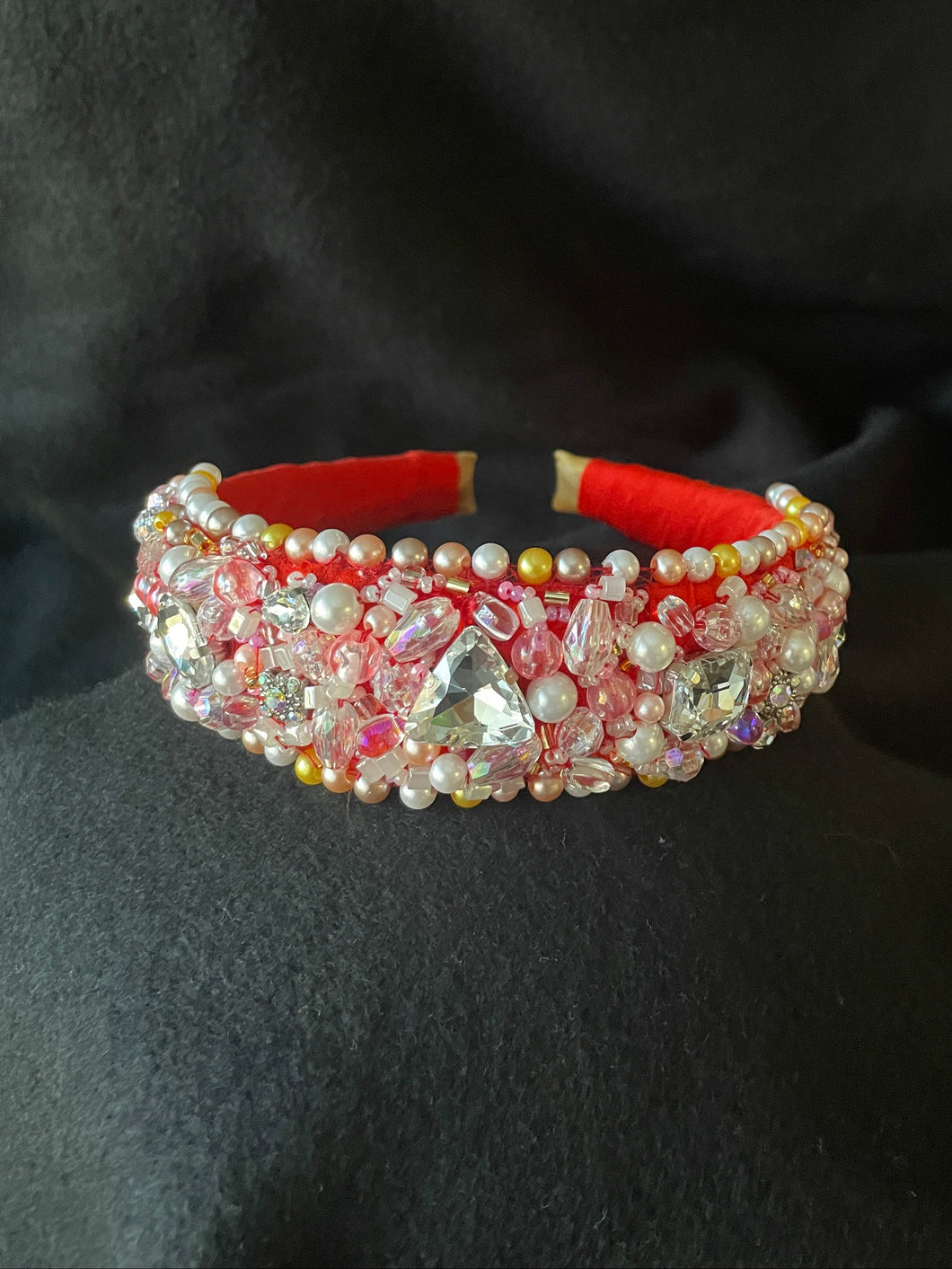 Decorative headband with red and multicolored beads on a black background