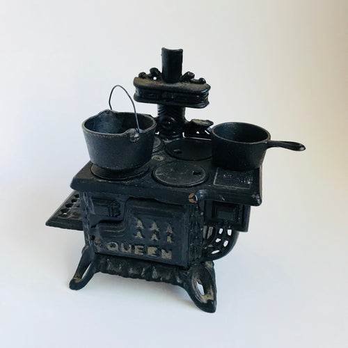 Vintage cast iron toy stove with 2 pots